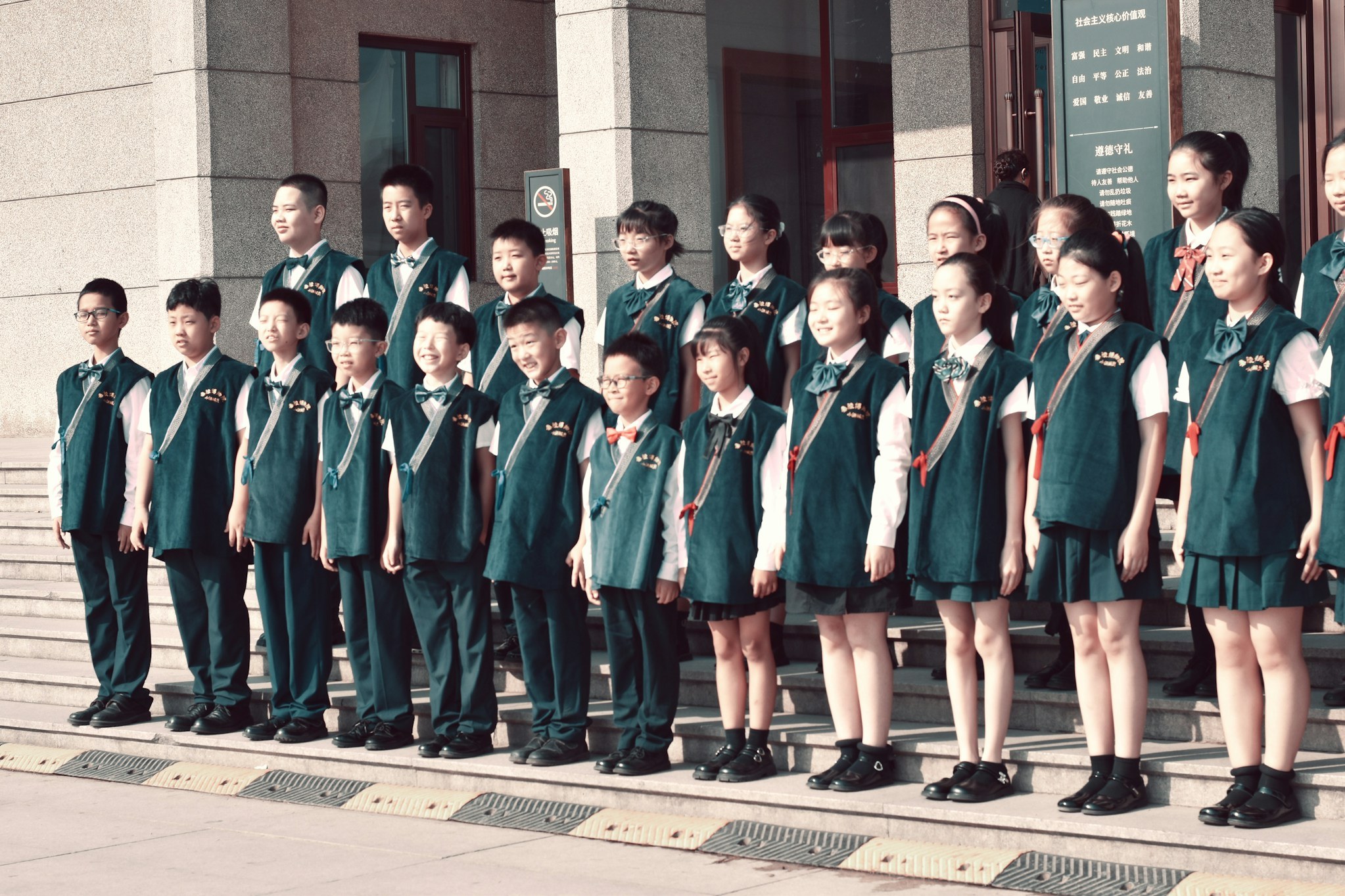 Students in school uniforms lined up outside their school