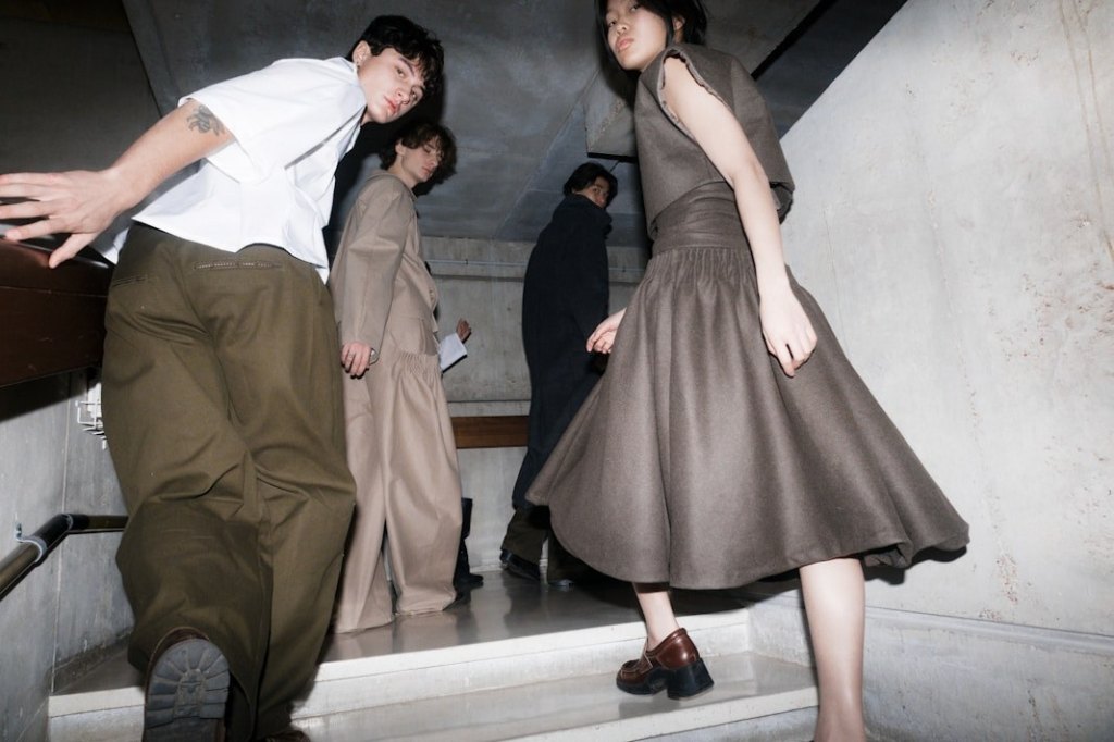 Models presenting a tailored collection on a staircase