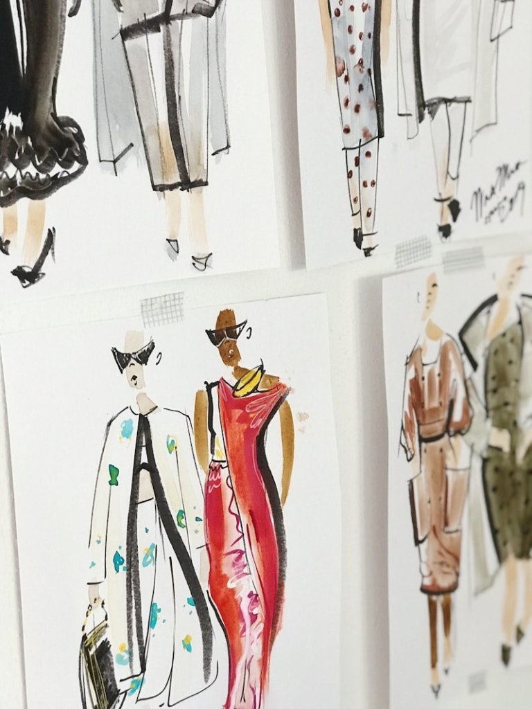 Fashion design sketches pinned on a board